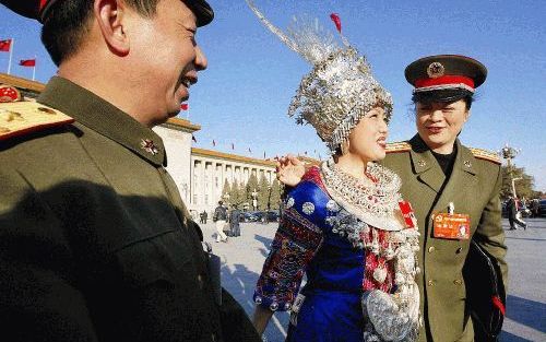 PEKING - Veelal in prachtige traditionele kledij gestoken Chinese afgevaardigden, zoals deze vrouw van de etnische Miao-minderheid uit het zuidwesten van het land, begonnen vrijdag in Peking in de Grote Hal van het Volk aan het zestiende partijcongres. Ro