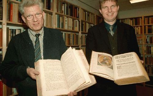 TERNEUZEN - Ds. J. Wever (l.) en dr. K. Rieske-Braun uit Aken zijn verguld met de aanschaf van een manuscript over de reformatiegeschiedenis van de Duitse stad. Vrijdag kochten ze het document van boekhandelaar Hamelink in Terneuzen. - Foto Charles Strijd