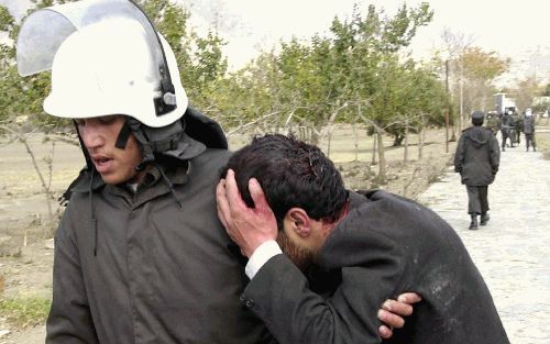 KABUL - Een politieagent in de Afghaanse hoofdstad Kabul voert een gewonde student weg tijdens protesten tegen de slechte omstandigheden op de universiteit in de stad. Twee studenten kwamen dinsdag bij de onlusten om het leven. - Foto EPA