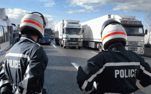 LYON - Franse politieagenten keken maandag naar blokkades met trucks op de A46 in Lyon. De truckers blokkeerden maandag op een tiental plaatsen de wegen. Inmiddels zijn de acties op de weg beÃ«indigd. - Foto EPA