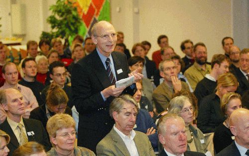 EDE - Een van de aanwezigen op het RRQR-congres, drs. P. Scheer, stelt een vraag tijdens de forumdiscussie. Oud-leden van de studentenvereniging CSFR bezonnen zich afgelopen zaterdag in Ede tijdens hun jaarlijkse congres op het thema geloofsoverdracht. - 