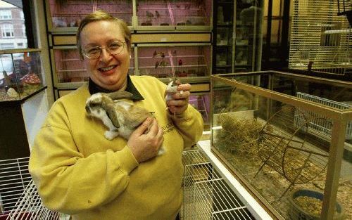 BARNEVELD - Anneke Vermeulen, voorzitter van het Platform Verantwoord Huisdierenbezit, met een konijn en een ratje in de hand. „De koper realiseert zich niet welke ellende hij aanricht door dieren te wensen die te jong zijn om van de moeder te worden gesc