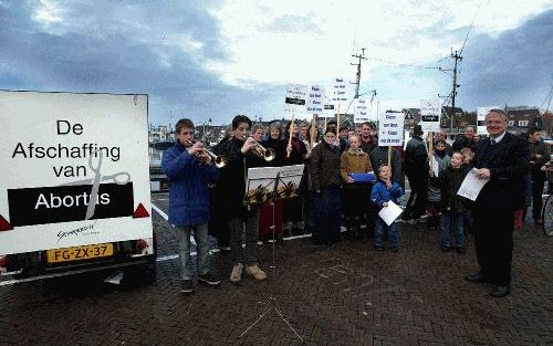 URK - Op de haven van Urk gaven twee trompettisten vrijdagmorgen het startsein voor de verkiezingsactie van de Stichting Schreeuw om Leven. De komende weken willen voorzitter Dorenbos (rechts met vel papier in de hand) en de zijnen in diverse plaatsen pro