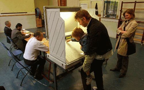 ROTTERDAM - Een Rotterdammer laat bij de vorige verkiezingen voor de Tweede Kamer zijn zoontje de stemcomputer bedienen in stembureau nummer 161, aan de Beukelsdijk. Veruit de meeste stemcomputers op de Nederlandse markt zijn geleverd door Nedap in Groenl