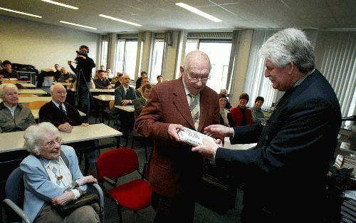 EDE - Prof. dr. H. N. Ridderbos neemt het laatste nieuwtestamentische deel van de Studiebijbel in ontvangst. Links zijn vrouw, rechts ds. J. C. Bette, voorzitter van het Centrum voor Bijbelonderzoek, de organisatie die de Studiebijbel uitgeeft. - Foto RD,