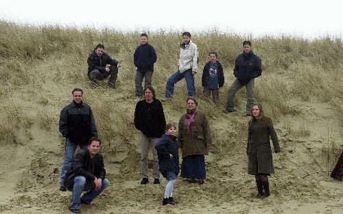 DEN BURG - Hans en Emmy van Es met negen van hun elf kinderen op het Texelse strand. Ze zijn trots op hun grote gezin. Maar toch. Op de achtergrond -en niet zelden ook op de voorgrond- spelen de financiÃ«le zorgen. „Vluchten kan niet.” - Foto Edo Kooiman