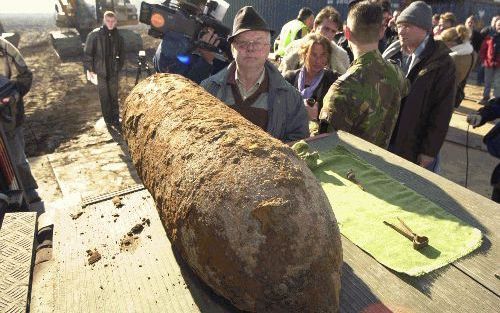 BIGGEKERKE - Pieter Lampert sr. bij de bom die gisteren op het strand in Vrouwenpolder tot ontploffing is gebracht. Het Engelse projectiel werd op 17 september 1944 afgeworpen. Bij het bombardement vonden die dag tientallen inwoners van Biggekerke de dood