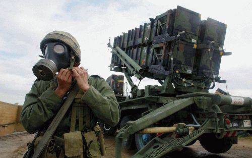 KFAR HAIM - Een IsraÃ«lische soldaat zet zijn gasmasker af bij een lanceerinrichting van Patriot-raketten op de luchtmachtbasis Kfar Haim in het midden van IsraÃ«l. Kfar Haim is een van de belangrijkste IsraÃ«lische bases met het oog op een mogelijke aanv