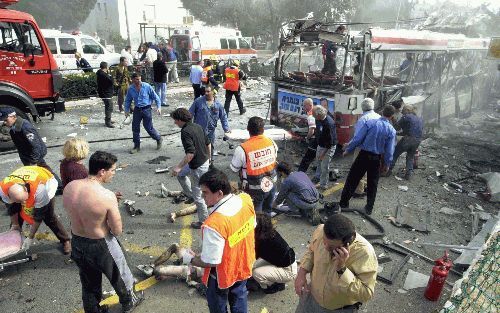 JERUZALEM - In Haifa krijgen gewonden eerste hulp. Bij een Palestijnse zelfmoordaanslag op een bus kwamen gisteren vijftien IsraÃ«liÃ«rs en de dader om het leven. - Foto EPA