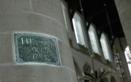 DELFT - Een ingemetselde steen in een pilaar van de Oude Kerk in Delft herinnert aan dichter Hubert Korneliszoon Poot. - Foto RD, Anton Dommerholt