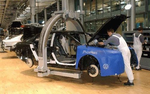 DRESDEN - Monteurs werken in de Glazen Fabriek van Volkswagen in Dresden in het voormalige Oost-Duitsland aan de bouw van een Phaeton. De productie van het vlaggenschip van VW geschiedt in de gehele fabriekshal op houten parketvloeren. Sinds mei vorig jaa