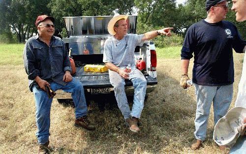 CRAWFORD - De Amerikaanse president George W. Bush (m.) met enkele vrienden op zijn ranch in Texas. - Foto EPA