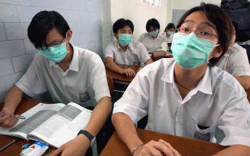 JAKARTA - Indonesische studenten van Chinese oorsprong zitten in een klaslokaal in Jakarta met een mondkapje voor om te voorkomen dat ze de longziekte SARS oplopen. Op een aantal particuliere scholen in de Indonesische hoofdstad is het dragen van een mond