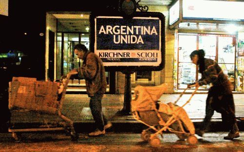 BUENOS AIRES - Een Argentijns gezin passeert een verkiezingsposter in de hoofdstad Buenos Aires. Volgende week zondag gaat de bevolking van het Zuid-Amerikaanse land naar de stembus voor de tweede ronde van de presidentsverkiezingen. - Foto EPA