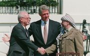 Bij de ondertekening van het eerste Oslo akkoord, dat voorzag in Palestijnse autonomie, drukt Arafat de IsraÃ«lische premier Yitzhak Rabin op 13 september 1993 de hand. Foto EPA