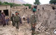KARBALA – Afghaanse militairen lopen tussen de in puin geschoten woningen van Karbala. Inwoner Hafizullah Isol (40): „De taliban schoten vanuit de boomgaarden, maar ISAF bombardeerde onze huizen.” Foto Joeri Boom