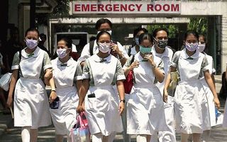 Verpleegkundigen in Manilla dragen mondkapjes om zich te beschermen ten het SARS-virus. Foto EPA