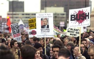 „Bush tracht niet alleen de Nederlandse overheid met dreigend geweld naar zijn hand te zetten.” Foto: tegenstanders van de Amerikaanse president tijdens een demonstratie in Londen. Foto EPA