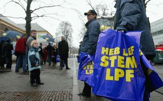 EMMEN - Medewerksters van de Lijst Pim Fortuyn (LPF) delen plastic tassen uit in het centrum van Emmen. Donderdag trok het LPF-campagneteam het land in voor de Tweede-Kamerverkiezingen van 22 januari. - Foto ANP