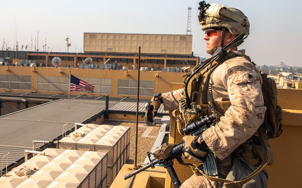 Een Amerikaanse militair waakt over de ambassade van de VS in Bagdad. beeld AFP