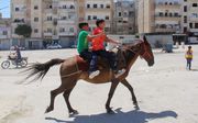 Kinderen op een paard in de Syrische stad Idlib. beeld AFP