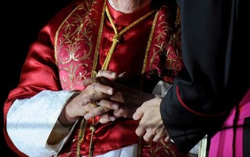 De paus luistert naar een bisschop. - Foto EPA