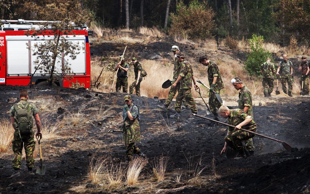 Brandweerlieden zijn maandag bezig met het nablussen van de brand op de Strabrechtse Heide bij Heeze. Foto ANP