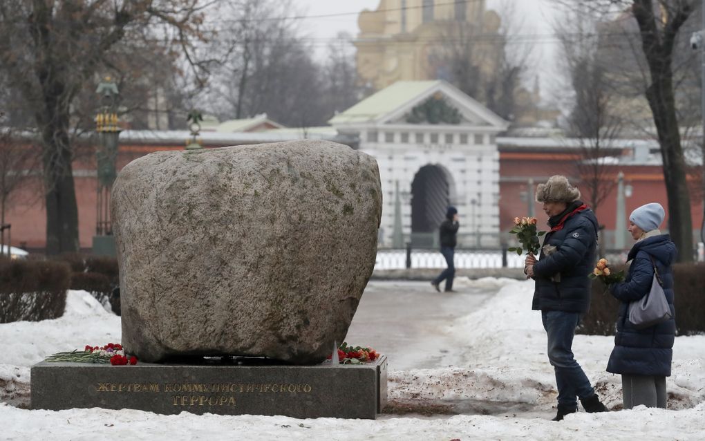 Mensen rondom een herdenkmounument voor overleden politieke gevangenen in Rusland. beeld EPA/ANATOLY MALTSEV