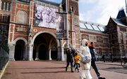 Toeristen passeren het Rijksmuseum, dat vanwege het Coronavirus gesloten is. beeld ANP