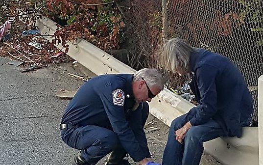 Brandweerman helpt met het aantrekken van de schoenen. Beeld facebook