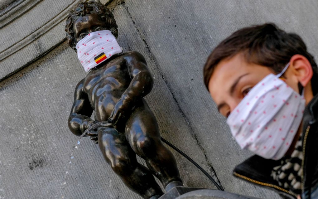 Manneken Pis met een medewerker van de gemeente Brussel. beeld EPA