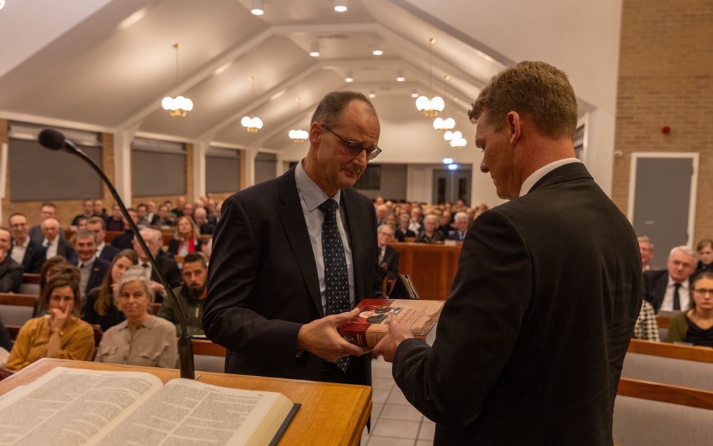 J.H. Madern (l.) vrijdagavond tijdens de presentatie van zijn boek ”Christus ingeplant. Verkenning in leven en werk van dr. Alexander Comrie (1706-1774) een scholastiek theoloog” (uitg. Gebr. Koster). Hij kreeg het eerste exemplaar overhandigd van zijn vriend, ds. J.J. Hoogerbrug (r.). beeld Martin Droog