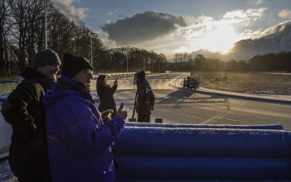 IJsmeesters kijken toe hoe in Winterswijk een ijsbaan wordt besproeid.  beeld ANP, Vincent Jannink