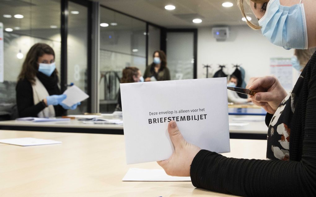 In het stadskantoor van Zwolle worden de briefstemmen verwerkt die per post zijn binnengekomen. Volgens een nieuwe procedure mag de briefstembiljetenvelop worden geopend om te zien of daar een stempas in zit. Daarna wordt gekeken of de stempas geldig is. beeld ANP, VINCENT JANNINK