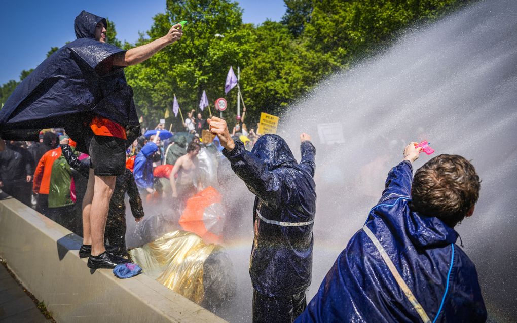 De politie zet een waterkanon in tegen activisten van Extinction Rebellion die de A12 in Den Haag voor de zevende keer blokkeren. beeld ANP, Phil Nijhuis