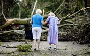 Twee vrouwen lopen tussen de omgewaaide bomen na een windhoos in Leersum. beeld ANP SEM VAN DER WAL