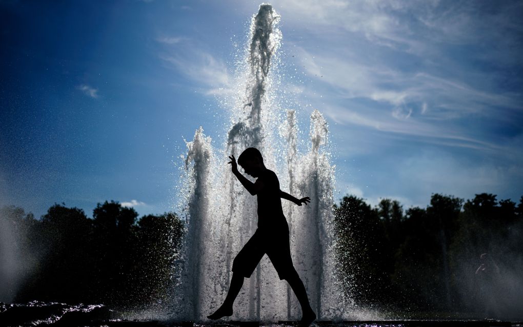 Een jongen loopt bij een fontein in het Lustgarten park in Berlijn, Duitsland. De Duitse weerdienst verwacht dat de hittegolf de komende dagen zal pieken, er worden maxima tussen 34 en 38 graden Celsius voorspeld in grote delen van Duitsland. beeld EPA, Clemens Bilan 