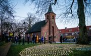 Waxinelichtjes branden tijdens de herdenking van coronaslachtoffers in de Hasseltse Kapel. Tilburg staat stil bij het uitbreken van de coronapandemie in Nederland, precies een jaar geleden. beeld ANP, ROB ENGELAAR