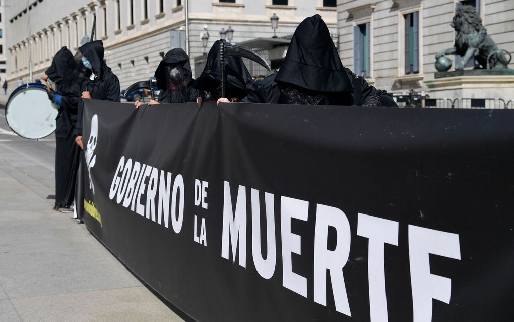 Protesters hold a placard reading "Government of death" during a demonstration against a law legalising euthanasia. image AFP, Javier Soriano