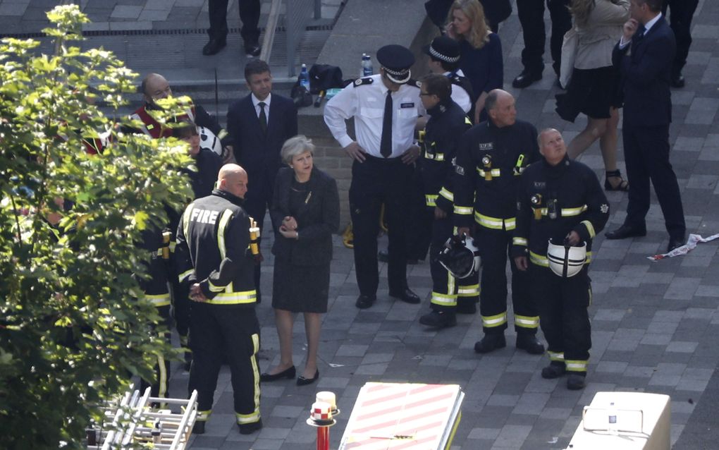 De Britse premier May donderdagochtend bij de uitgebrande Grenfell Tower. beeld AFP