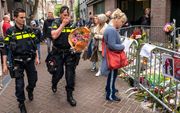 Mensen leggen donderdag bloemen voor Peter R. de Vries achter in de Lange Leidsedwarsstraat in Amsterdam. beeld ANP, EVERT ELZINGA