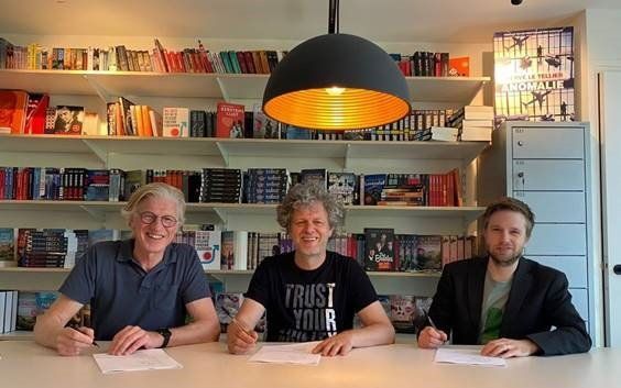Jeroen Windmeijer (m) en Tjarko Evenboer (r) tekenen met Sander Knol van Xander Uitgevers een contract voor een religieus-historische trologie. beeld Xander Uitgevers