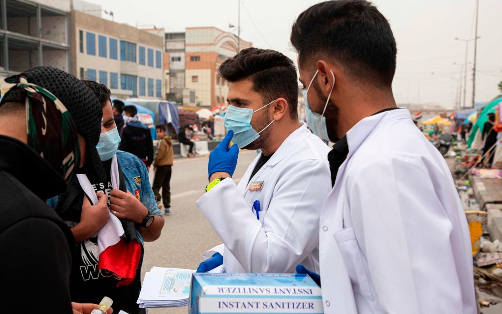 Studenten verspreiden informatie over het coronavirus in Basra, een stad in het zuiden van Irak. beeld AFP