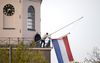 De Nederlandse vlag wordt gehesen voor Koningsdag op de Grote kerk. beeld ANP, Sander Koning