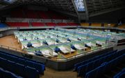 Een stadion in Peking is omgetoverd tot koortskliniek. Om ziekenhuizen te ontlasten, kunnen minder ernstig zieke coronapatiënten hier herstellen. beeld AFP, Jade Gao