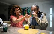 Een zorgverlener helpt een alzheimerpatiënt. Een nieuw medicijn, donanemab, kan het ziekteproces bij alzheimerpatiënten helpen vertragen. beeld AFP, Clement Mahoudeau