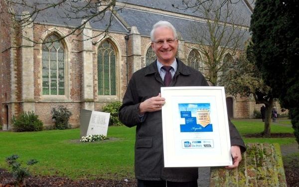 „Ik houd echt van Kapelle”, zegt SGP-wethouder L. F. Kosten. In zijn hand de oorkonde waarop staat dat het Zeeuwse dorp is uitgeroepen tot Gemeente van het Jaar 2011. Foto RD