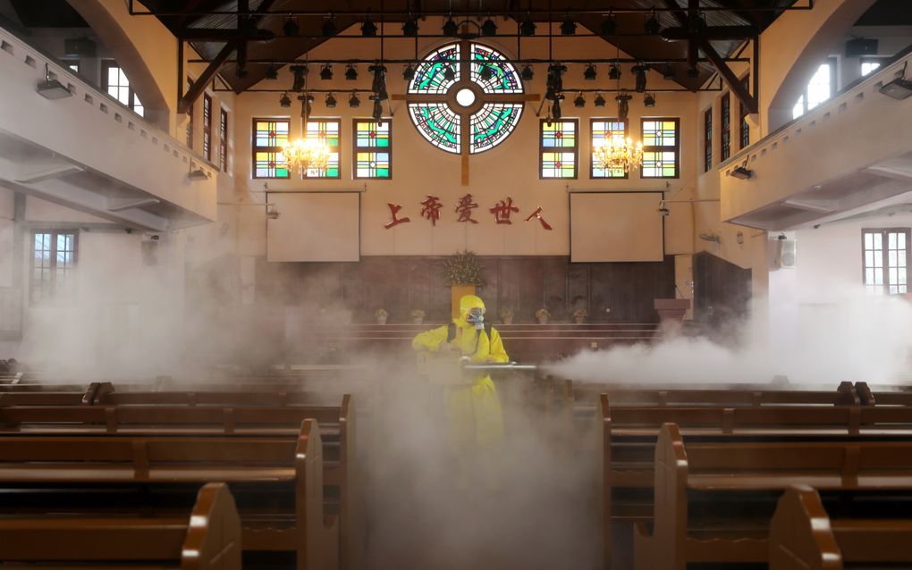 Een kerk in Wuhan wordt gedesinfecteerd. beeld EPA