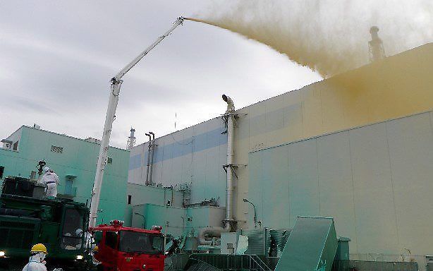 Een onlangs vrijgegeven foto toont reddingswerkers die met een vloeistof proberen de Fukushima-centrale te stabiliseren. Foto EPA