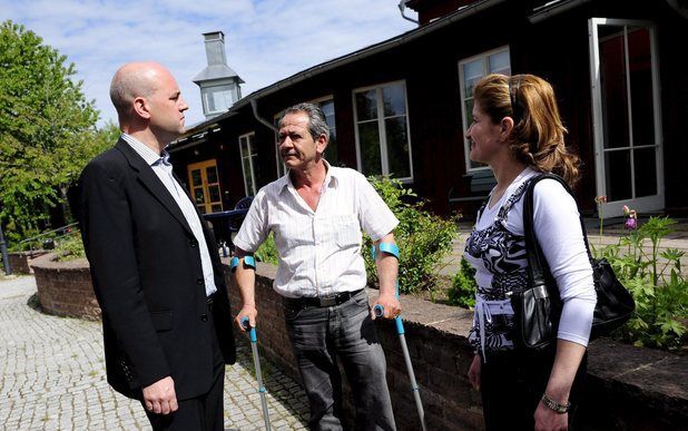 STOCKHOLM - De Zweedse premier Fredrik Reinfeldt (links), praat met de Iraakse christenen Bassel Yousef en Lamiaa Al-Sammak in Sodertalje, 26 mei 2008. De twee willen niet terug naar Irak. Sodertalje, een stad met 83.000 inwoners, heeft sinds de Amerikaan